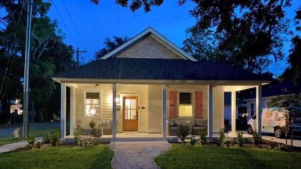 A single-story house with a covered porch, a front door, and a driveway leading to the entrance. - Palm Cottage, at Magnolia Court Suites (Beaufort)