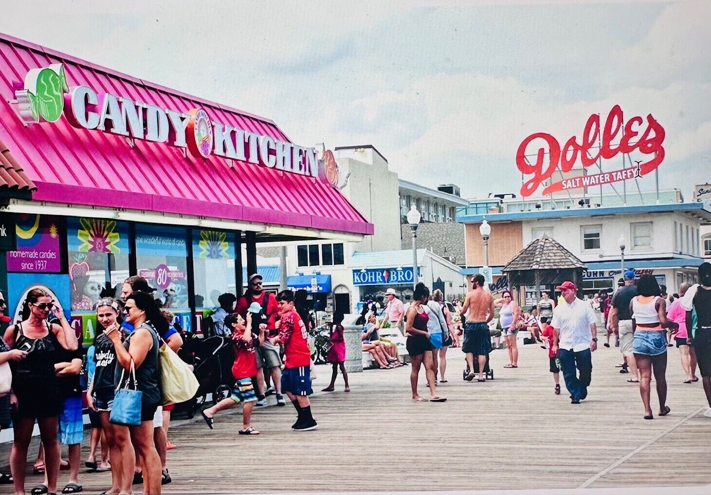 Un paseo marítimo con diversas tiendas, incluyendo una dulcería y una tienda de caramelo de agua salada.