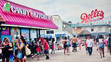 Un paseo marítimo con diversas tiendas, incluyendo una dulcería y una tienda de caramelo de agua salada.