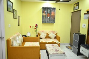 Cozy living area with a sofa, table, and vase with flowers.