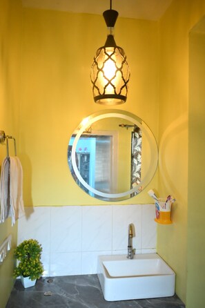Bathroom features a sink, mirror, and decorative light fixture.