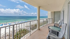 A balcony with a view of the beach and ocean.