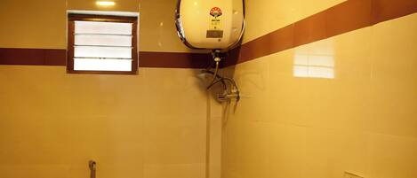 A bathroom with a toilet, a shower, and a sink.