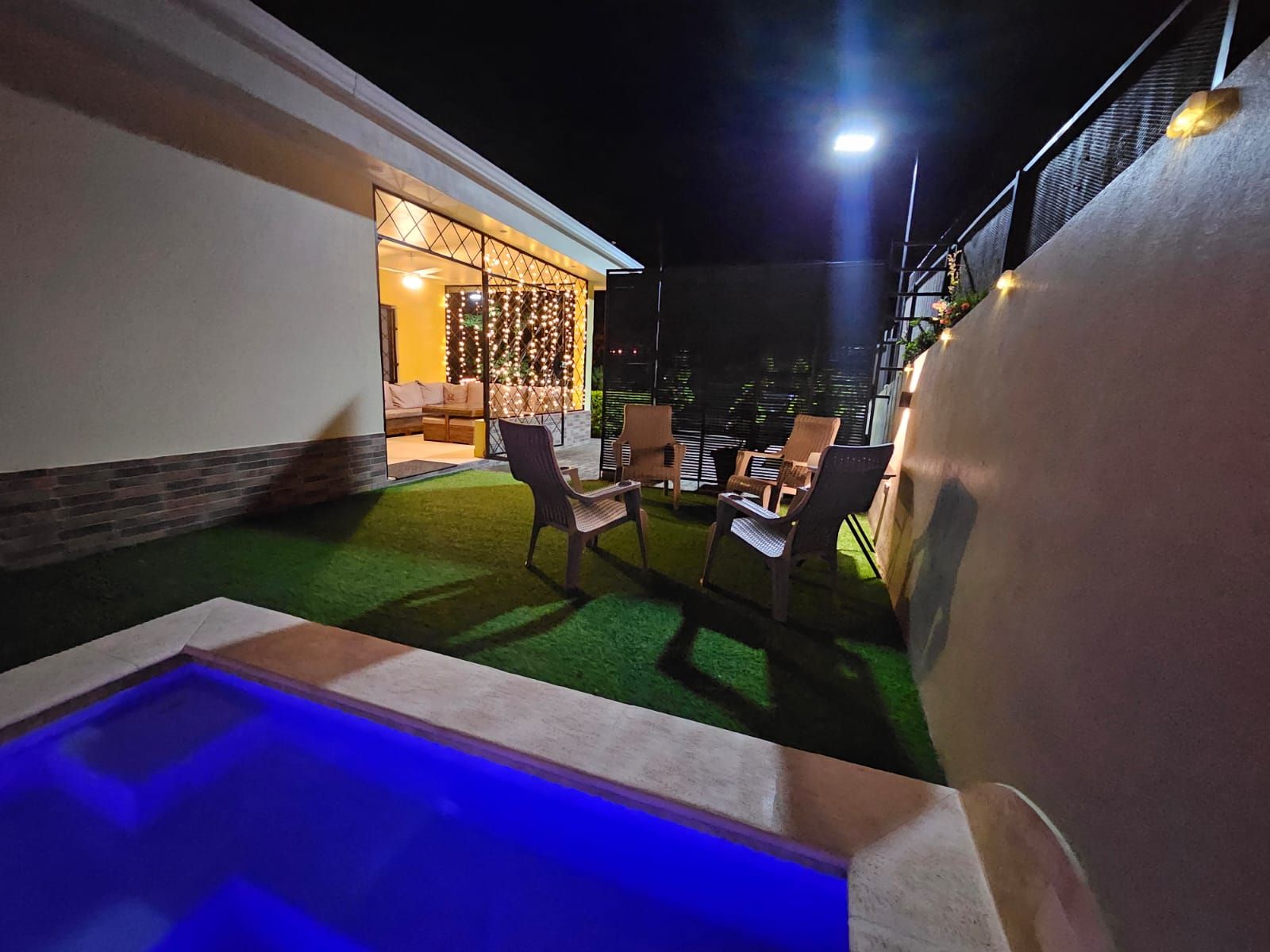 An outdoor patio area with a pool, seating, and a building entrance.