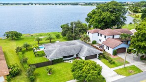 A residential property with a large lawn, a swimming pool, and a view of a lake. - Private pool home near downtown & beach (West Palm Beach)