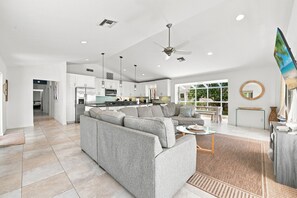A modern living room with a grey sectional sofa, a coffee table, and a television.