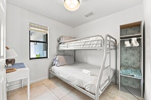 Habitación con literas, escritorio, ventana y armario.