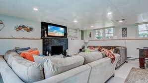 A living room with a sectional sofa, a fireplace, and a television.