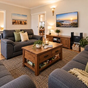 A living room with a grey sofa, wooden coffee table, and a television.