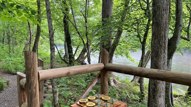 A wooden fence with a small wooden structure containing a board game. - Cozy Riverside Studio in the Heart of Townsend (Townsend)