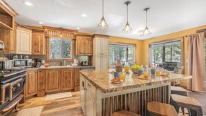 A spacious kitchen with wooden cabinets, a large island, and modern appliances.