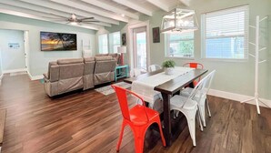 Un'ampia zona giorno con soffitto in legno, un tavolo da pranzo con sedie e un divano.