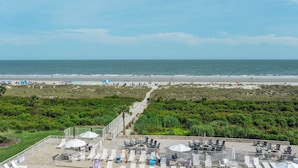 Un patio frente a la playa con mobiliario exterior y vistas al mar.