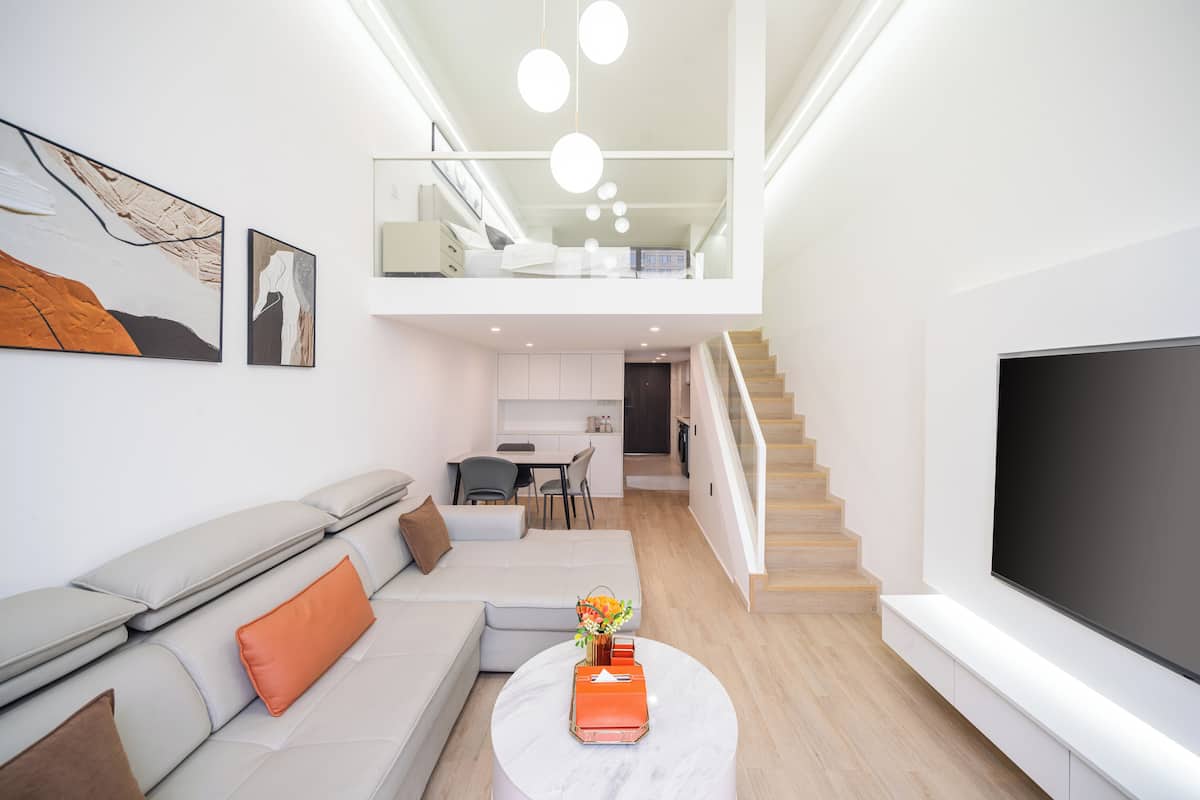 Uma sala de estar moderna com sofá, mesa de centro e obras de arte nas paredes.