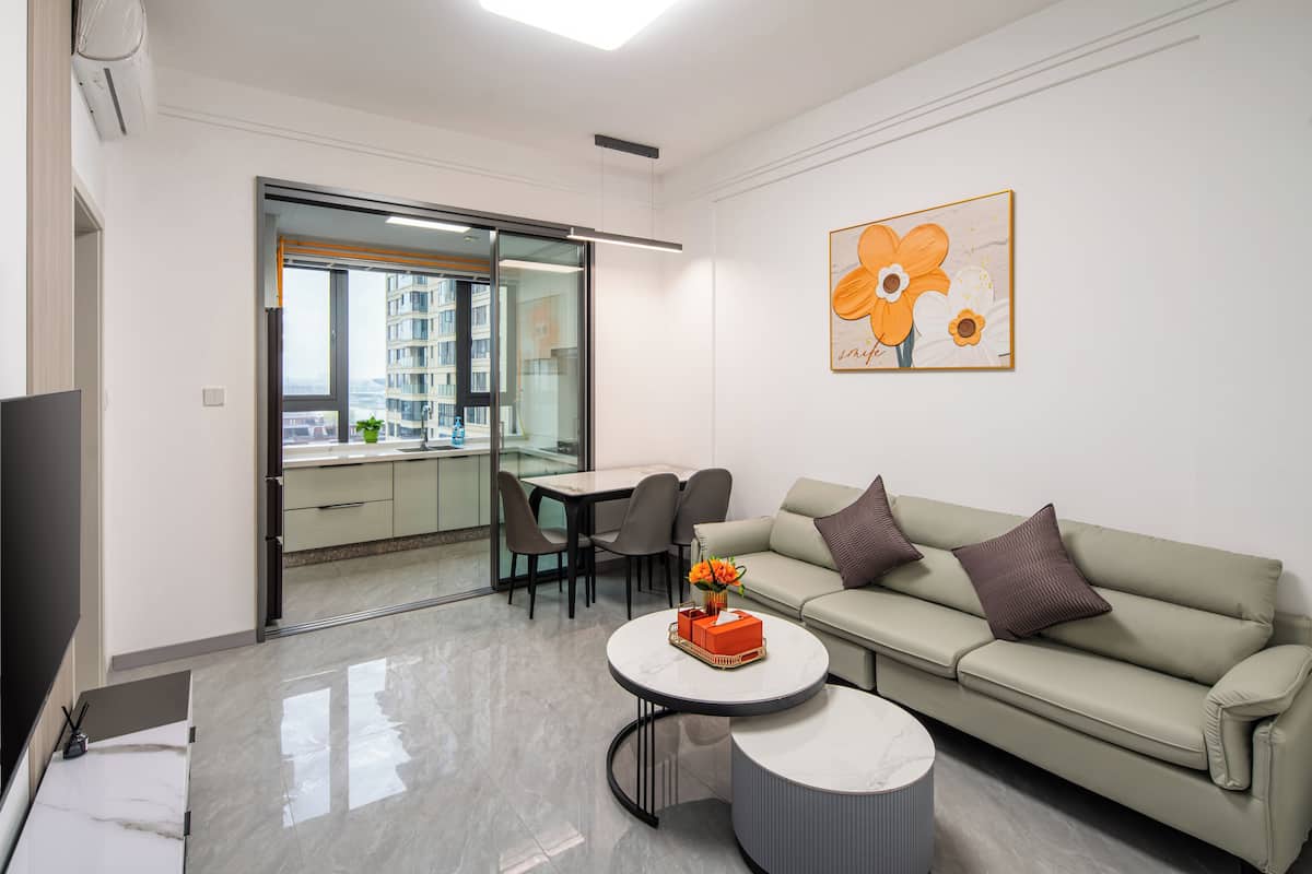 Uma sala de estar moderna com um sofá, mesa de centro e um quadro na parede.