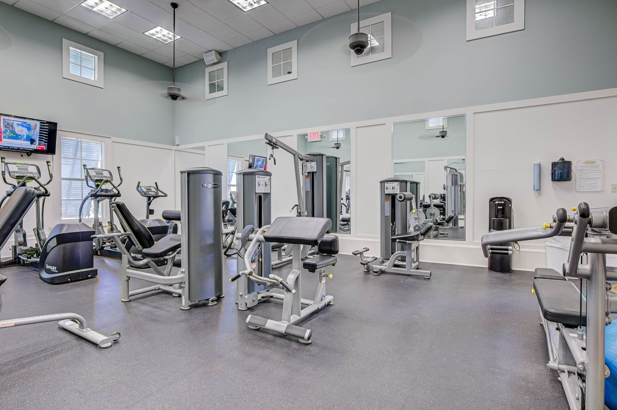 A gym with various exercise equipment, including treadmills, weight machines, and free weights.