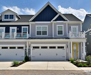 Ein zweistöckiges Wohnhaus mit Garage, Balkon und Eingangstür.