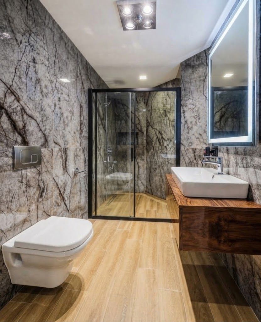 Une salle de bain moderne avec un mur en marbre, une cabine de douche en verre, un meuble-lavabo en bois et des toilettes.
