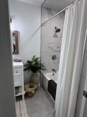 Chuveiro, toalhas de banho, papel higiênico