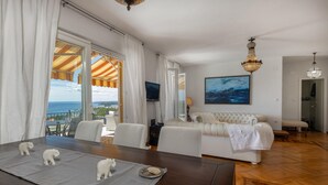 A modern living room with a sofa, a dining table with elephant figurines, a TV, and a painting. - Pet friendly apartment in Banjol with WiFi (Banjol)