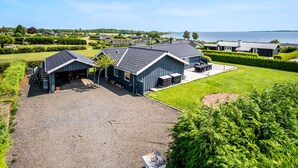 A residential area with houses, a large driveway, and a body of water in the background. - Stunning home in Faaborg (Faaborg)