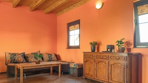 A cozy room with a wooden bench, a cabinet, and a window with a view.