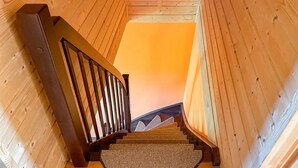 A wooden staircase with a handrail leading to a landing.