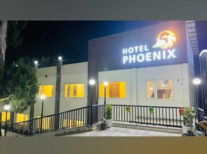 Et hotel, Phoenix, med en moderne facade, oplyst skiltning og et godt oplyst indgangsparti.