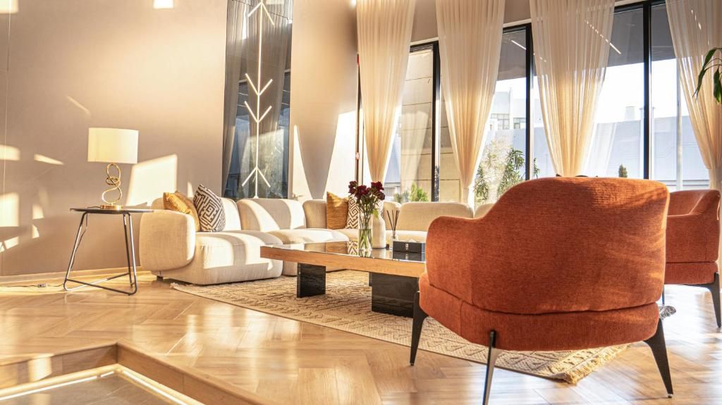 Een moderne woonkamer met een zithoek, een salontafel en een rode fauteuil.