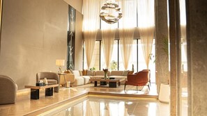 Een moderne woonkamer met een zithoek, een salontafel en een rode fauteuil.