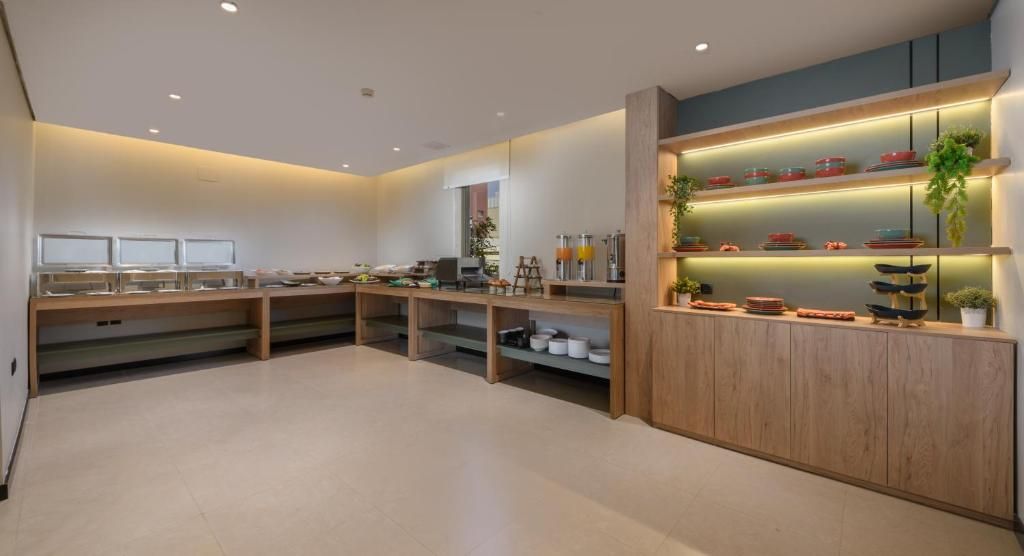A modern kitchen with wooden cabinets, built-in shelves, and a variety of kitchenware.