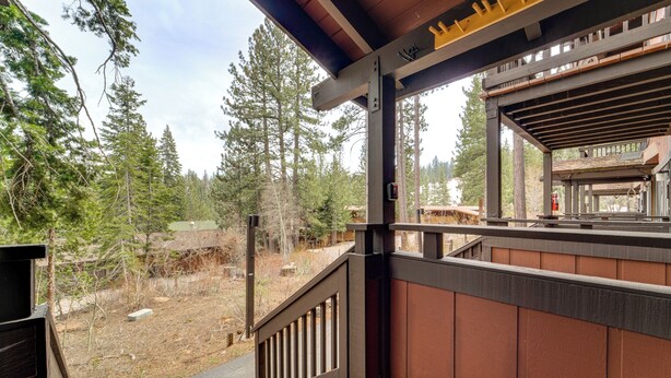 A wooden deck with a view of a forested area. - Hike, Sled & Ski! Cozy Tahoe City Condo w/ Hot Tub (Tahoe City)