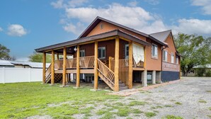 A two-story building with a covered porch and a staircase leading to the upper level.