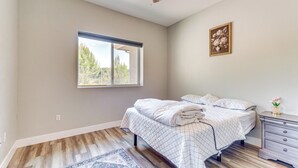 A bedroom with a bed, a nightstand, a window, and a ceiling fan. - Family Hideaway w/ Hillside Views in Temecula! (Temecula)