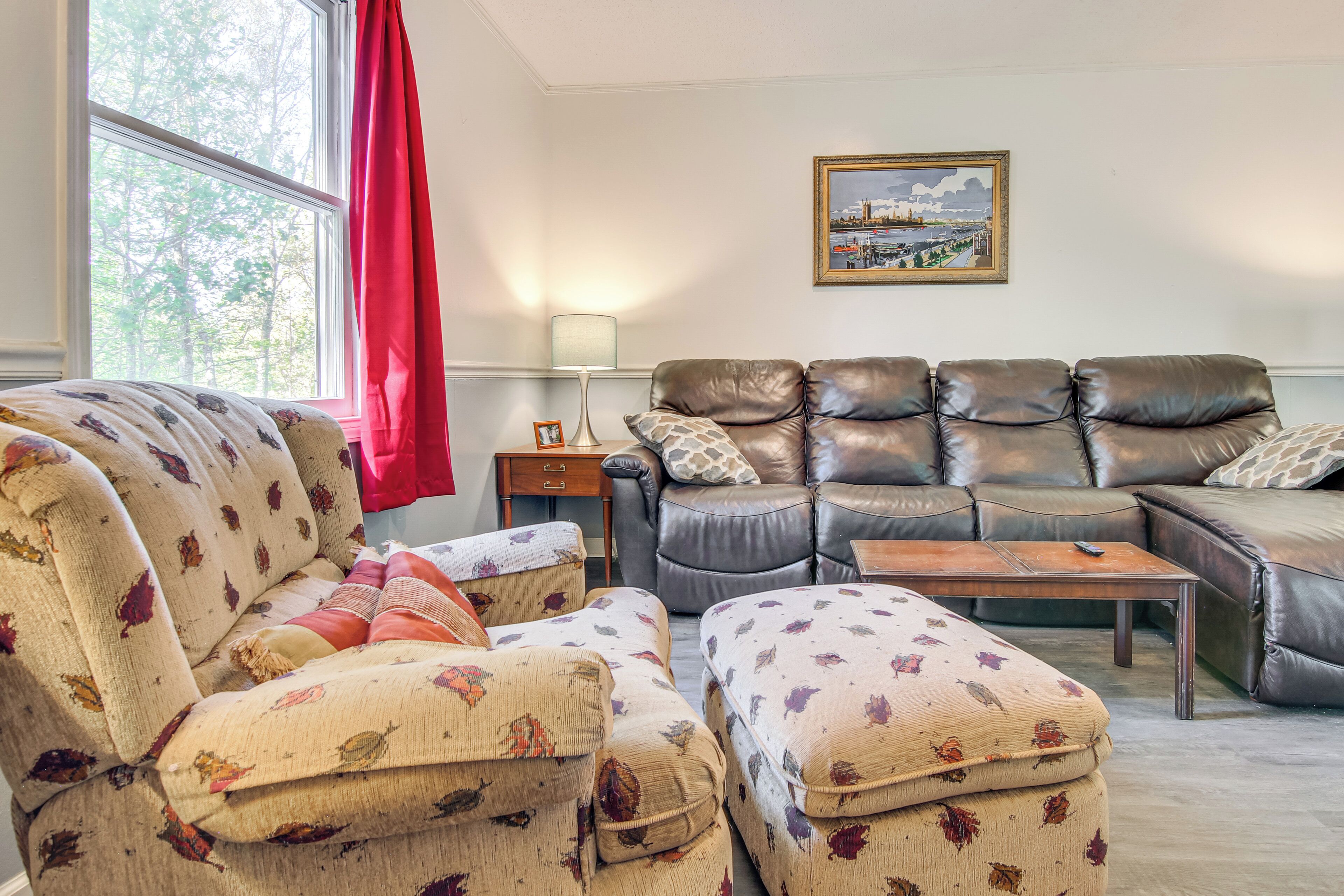 A living room with a floral sofa, a leather sofa, and a wooden coffee table.