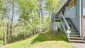 A building with a staircase leading to a porch, surrounded by a forested area. - 1 Mi to Pisgah Natl Forest: Wooded Haven w/ Deck (Pisgah Forest)