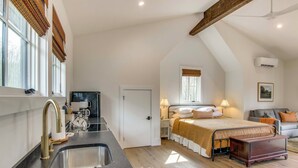 Un dormitorio con cama, mesita de noche y ventana.