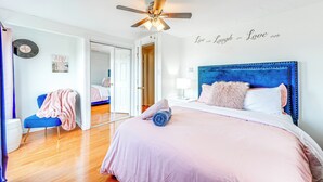 A bedroom with a bed, a ceiling fan, a chair, a nightstand, and a wall clock. - Poconos Group Getaway w/ Game Room + Fire Pit! (Gouldsboro)