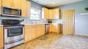 A kitchen with wooden cabinets, a stainless steel oven, a microwave, and a dishwasher. - Algoma Lake Michigan Home w/ Game Room & Deck (Algoma)