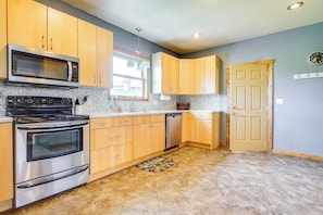 A kitchen with wooden cabinets, a stainless steel oven, a microwave, and a dishwasher. - Algoma Lake Michigan Home w/ Game Room & Deck (Algoma)