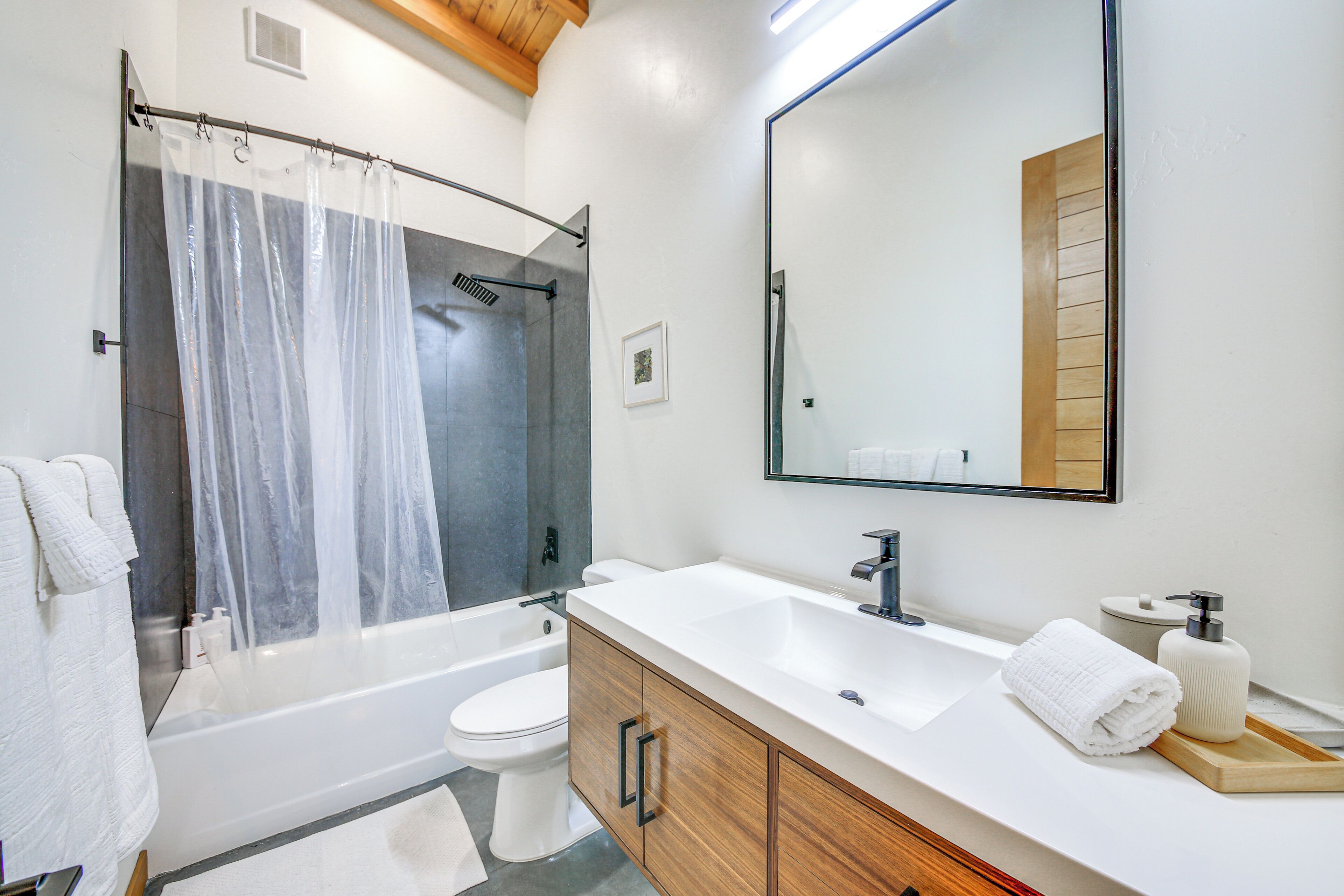 Un baño moderno con bañera, inodoro y tocador.