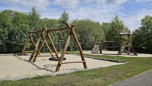 A playground with wooden swings and a climbing structure. - Mountain idyll -renovated and high quality with solid wood bed at comfort height (Altenberg)