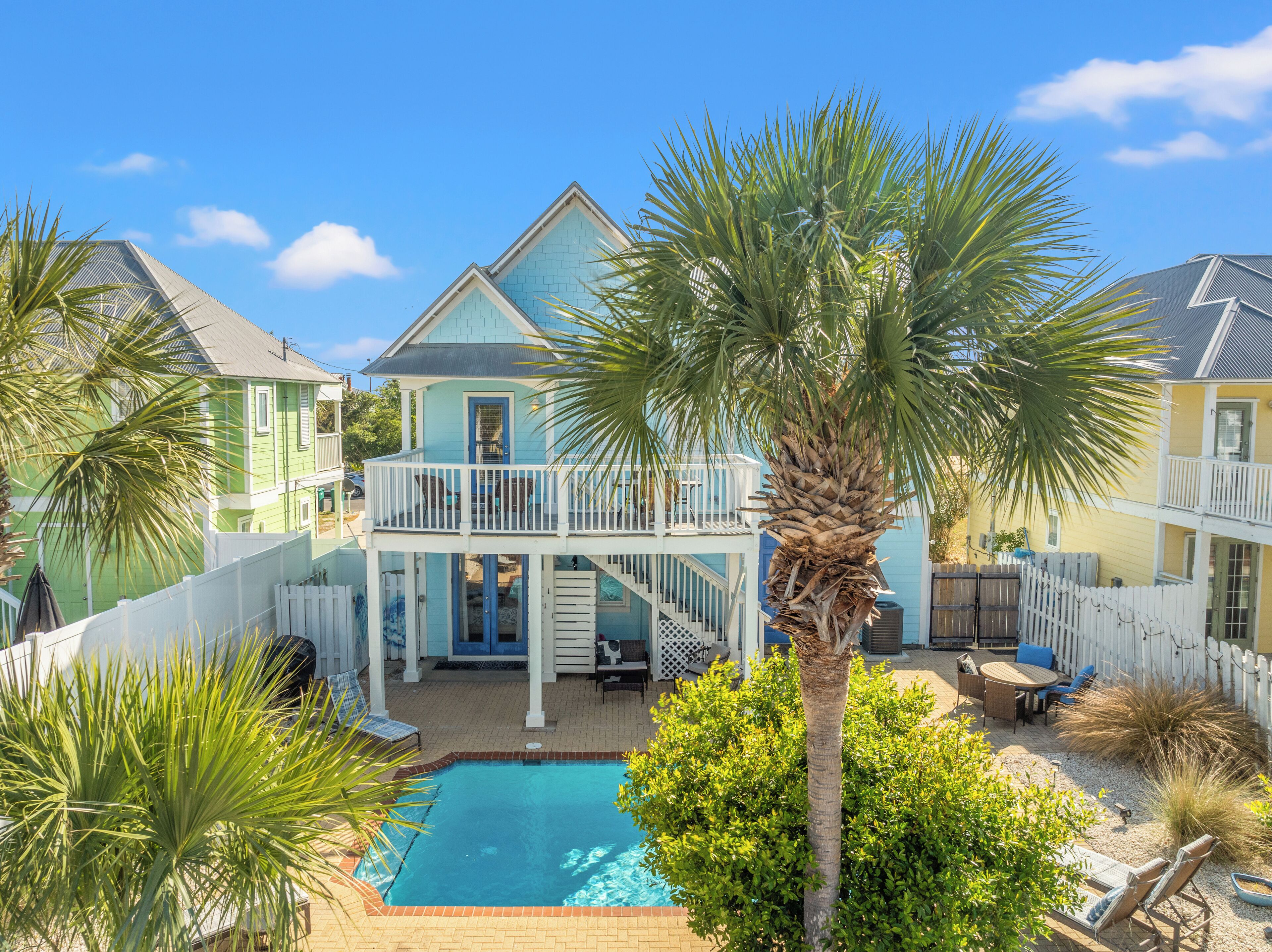 A two-story house with a balcony, a swimming pool, and a fenced patio area.