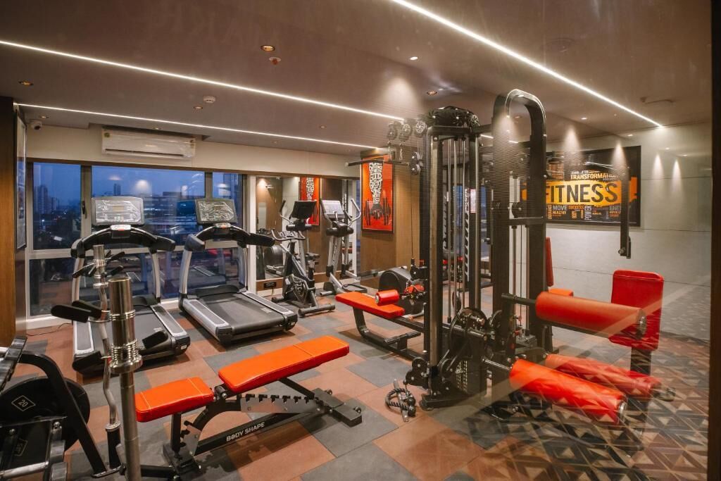 Ein Fitnessstudio mit Laufbändern, Kraftgeräten und Bänken.