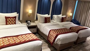 Een hotelkamer met twee bedden, een bureau en een nachtkastje.