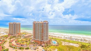 A high-rise hotel with a pool, located near a beach with clear blue waters. - Exquisite 2B Gulf View Condo at Portofino 4-2006 (Pensacola Beach)