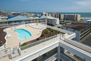 Un hôtel doté d’une piscine, de chaises longues et offrant une vue sur l’océan.