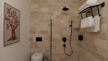 Luxe tweepersoonskamer | Badkamer | Een haardroger, pantoffels, handdoeken, zeep