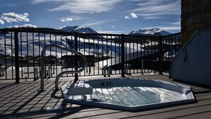 A hot tub on a wooden deck with a view of snow-covered mountains. - Spacious condo centrally located in Silverthorne! (Silverthorne)