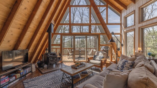 A cozy loft-style room with a large wooden ceiling, a television, a fireplace, and a comfortable seating area with a couch and chairs. - Timberline Lodge by Innsbrook Vacations! (Innsbrook)